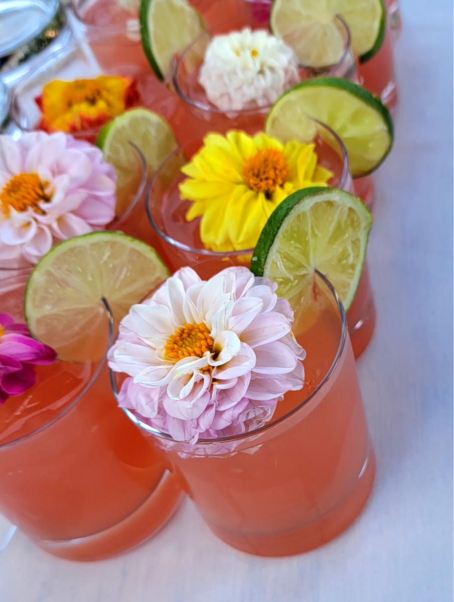 a table topped with glasses filled with drinks and flowers