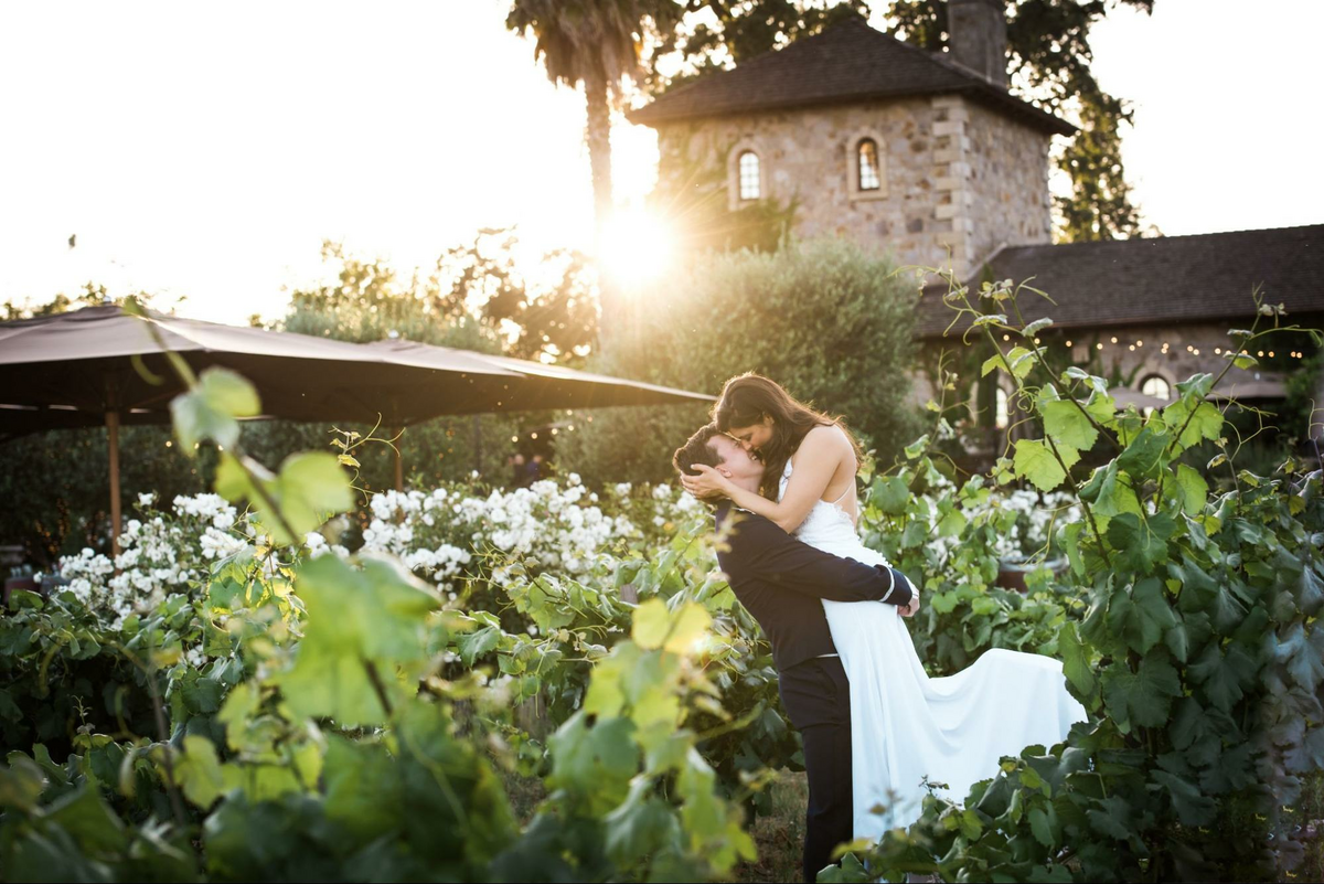 a bride and groom embracing in a garden